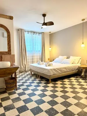 a bedroom with a large bed and a checkered floor at Maison typique Corse en pleine nature in Fozzano