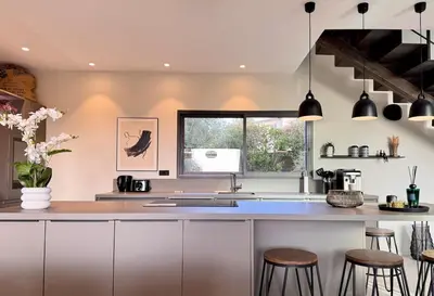 a kitchen with white cabinets and bar stools at Villa di Stella Pinarello - Proche plage - swimming pools in Sainte-Lucie de Porto-Vecchio