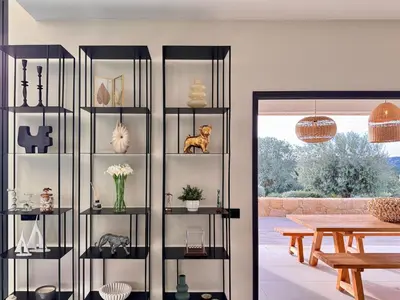a living room with a book shelf filled with items at Villa di Stella Pinarello - Proche plage - swimming pools in Sainte-Lucie de Porto-Vecchio