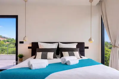a bedroom with a large bed with towels on it at Villa di Stella Pinarello - Proche plage - swimming pools in Sainte-Lucie de Porto-Vecchio