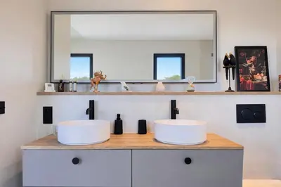 a bathroom with two sinks and a mirror at Villa di Stella Pinarello - Proche plage - swimming pools in Sainte-Lucie de Porto-Vecchio