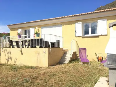 a house with a table and a purple chair at maison être mer et montagne in Ponte-Leccia