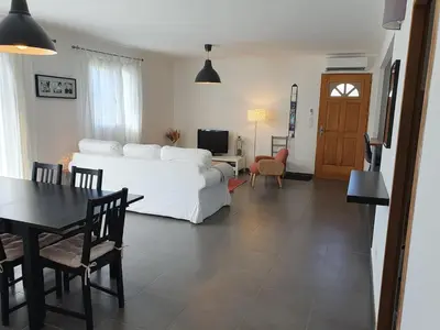 a bedroom with a white bed and a table and chairs at maison être mer et montagne in Ponte-Leccia