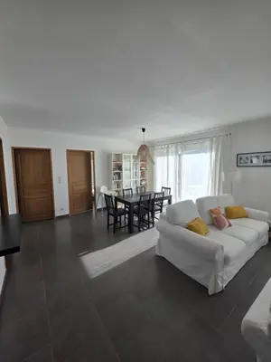 a living room with a white couch and a table at maison être mer et montagne in Ponte-Leccia