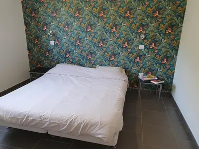 a bedroom with a bed with a floral wallpaper at maison être mer et montagne in Ponte-Leccia