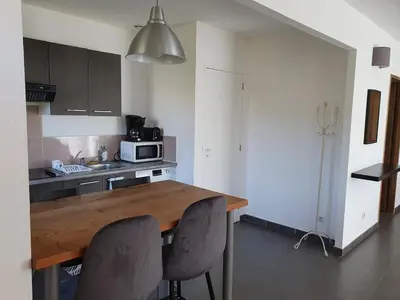a kitchen with a wooden table and two chairs at maison être mer et montagne in Ponte-Leccia