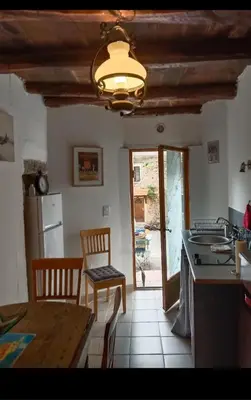 a kitchen with a table and a refrigerator and a table at Maison typique village corse in Sari-dʼOrcino