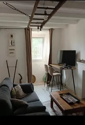 a living room with a couch and a desk with a computer at Maison typique village corse in Sari-dʼOrcino