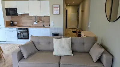 a living room with a couch and a kitchen at T3 Casa di Giulia neuf grande terrasse - Lumineux - Plage à 5 min in Zonza