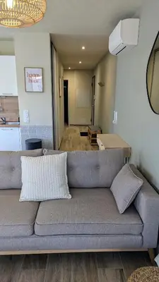 a living room with a gray couch and a kitchen at T3 Casa di Giulia neuf grande terrasse - Lumineux - Plage à 5 min in Zonza