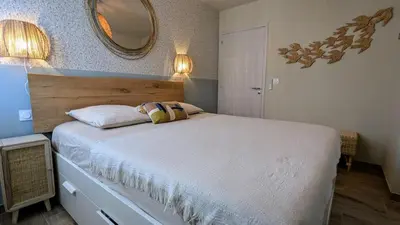 a bedroom with a large bed with a mirror on the wall at T3 Casa di Giulia neuf grande terrasse - Lumineux - Plage à 5 min in Zonza