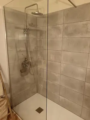 a shower with a glass door in a bathroom at Authentique maison de hameau in Altagene