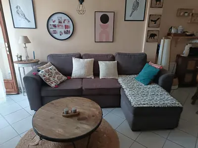 a living room with a purple couch and a table at Authentique maison de hameau in Altagene