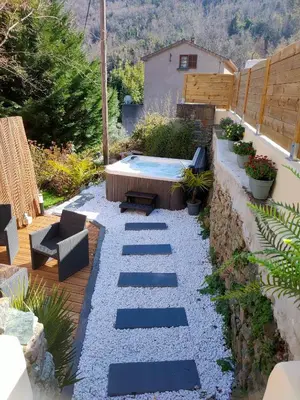 a hot tub in a garden with stairs and plants at La Casa Serena - Maison avec SPA in Ortiporio