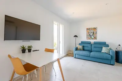 a living room with a blue couch and a table at Studio neuf , vue mer et montagne in Lavatoggio