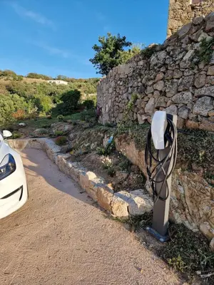 a pay phone sitting on the side of a stone wall at Studio neuf , vue mer et montagne in Lavatoggio