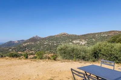 a blue picnic table in front of a mountain at Studio neuf , vue mer et montagne in Lavatoggio