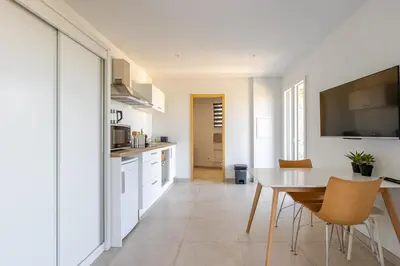a kitchen and dining room with a table and chairs at Studio neuf , vue mer et montagne in Lavatoggio