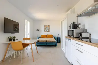 a kitchen with a table and a bed in a room at Studio neuf , vue mer et montagne in Lavatoggio