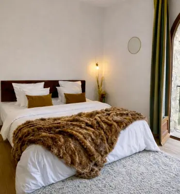 a bedroom with a bed with a faux fur blanket on it at Un étage entier - 5 chambres indépendantes et 3 salles de bains in Corte