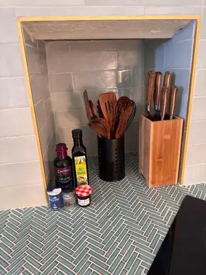 a shelf with a bottle of alcohol and wooden utensils at Elegant 2-bedroom terrace in the heart of the city in Ajaccio