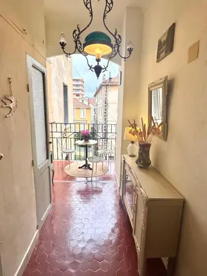 a hallway with a chandelier and a table on a balcony at Elegant 2-bedroom terrace in the heart of the city in Ajaccio