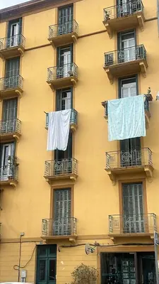 a yellow building with clothes drying on the balconies at Elegant 2-bedroom terrace in the heart of the city in Ajaccio