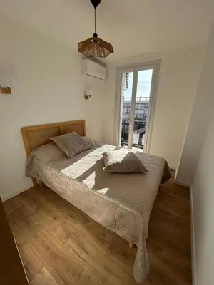a bedroom with a large bed with a window at T2 Cosy Centre Ajaccio in Ajaccio