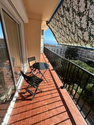 a patio with a table and a chair on a balcony at T2 Cosy Centre Ajaccio in Ajaccio