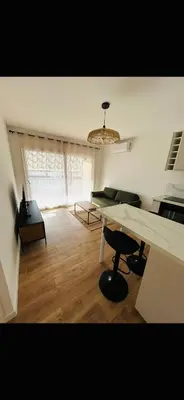 a living room with a table and a large window at T2 Cosy Centre Ajaccio in Ajaccio