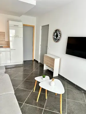 a living room with a couch and a table at Hébergement avec piscine in Sotta
