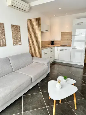 a living room with a couch and a table at Hébergement avec piscine in Sotta