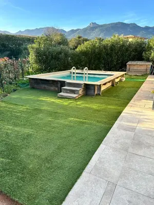 a swimming pool in the middle of a grass yard at Hébergement avec piscine in Sotta