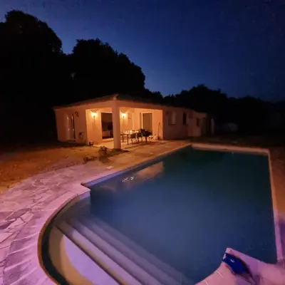 a swimming pool in front of a house at night at Casa Alivu in Pietrosella