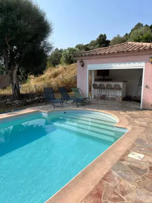 a swimming pool in front of a house with a table and chairs at Casa Alivu in Pietrosella