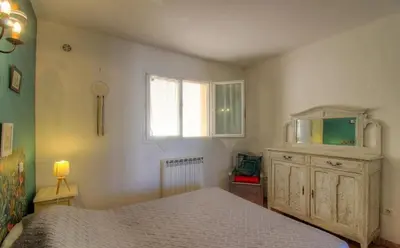 a bedroom with a bed and a dresser and a window at Location familiale 6 personnes entre Propriano et Olmeto in Olmeto