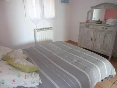 a bedroom with a bed with a mirror and a dresser at Location familiale 6 personnes entre Propriano et Olmeto in Olmeto