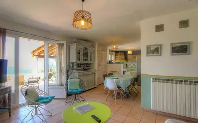 a kitchen and dining room with a table and chairs at Location familiale 6 personnes entre Propriano et Olmeto in Olmeto