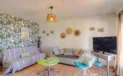 a living room with a couch and a flat screen tv at Location familiale 6 personnes entre Propriano et Olmeto in Olmeto