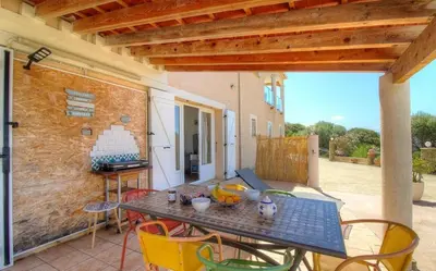 a patio with a table and chairs on a patio at Location familiale 6 personnes entre Propriano et Olmeto in Olmeto