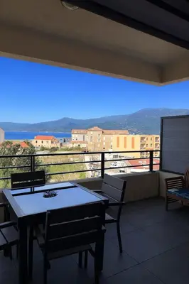 a balcony with a table and chairs and a view at Grand T2 vue mer à Propriano in Propriano