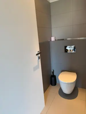 a bathroom with a white toilet in a room at Grand T2 vue mer à Propriano in Propriano