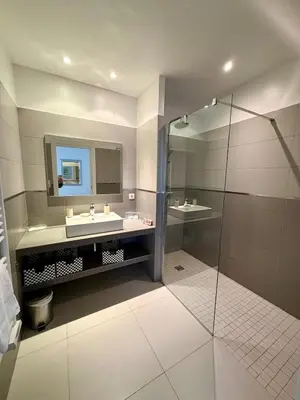 a bathroom with two sinks and a glass shower at Grand T2 vue mer à Propriano in Propriano