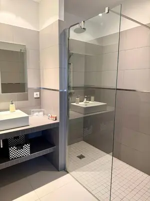 a bathroom with two sinks and a glass shower at Grand T2 vue mer à Propriano in Propriano