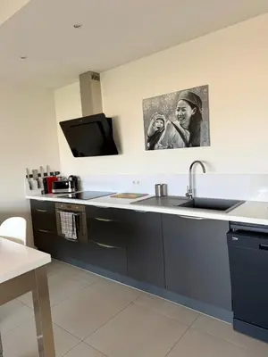 a kitchen with a sink and a tv in it at Grand T2 vue mer à Propriano in Propriano