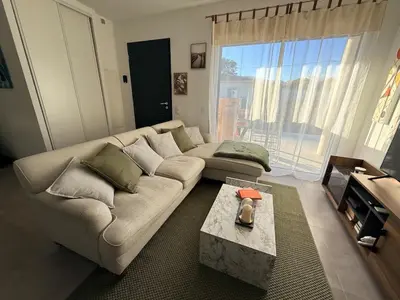 a living room with a couch and a table at Villa mitoyenne - Luxury house between sea and nature in Ghisonaccia