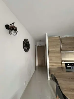 a dining room with a clock on the wall at Appartement pour 6 pers avec piscine in Zonza