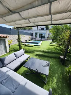 a kitchen and living room with a sink and a couch at Haut de villa avec piscine et jacuzzi proche d'Ajaccio in Cuttoli-Corticchiato