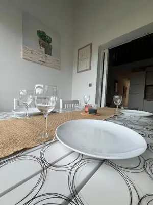 a table with wine glasses and a plate on it at Appartement bord de mer in San-Nicolao