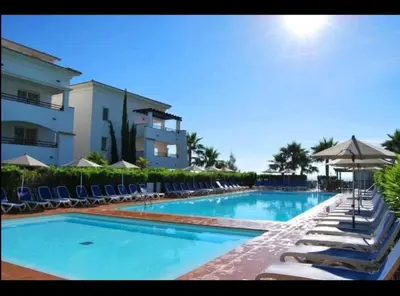 a swimming pool with lounge chairs and a building at Appartement bord de mer in San-Nicolao